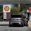 Gas prices rising with oil barrels in background showing energy crisis impact on consumers