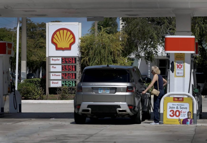 Gas prices rising with oil barrels in background showing energy crisis impact on consumers